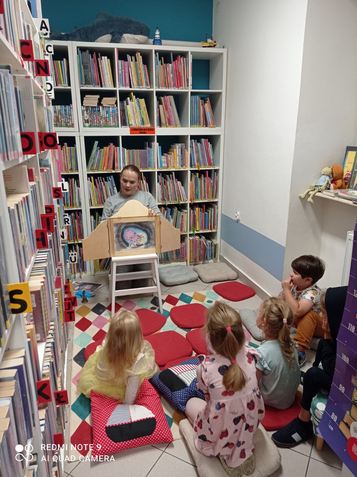 Bibliotekarka opowiada o wielorybku, widoczna grupa dzieci