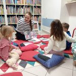 Bibliotekarka pokazuje dzieciom plansze bajki o myszce