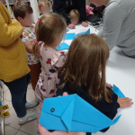 Grupa dzieci podczas wykonywania pracy plastycznej. Na pierwszym planie złożony wieloryb z origami
