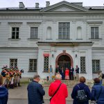 Oficjalne otwarcie pikniku - na tle drzwi pałacu w Falentach stoją m.in. prezeska Stowarzyszenia Projekt Raszyn 1809 Dorota Betko (przemawia) i starosta powiatu pruszkowskiego Adrian Ejssymont. Po lewej stoją rekonstruktorzy w mundurach z epoki