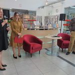Dyrektor biblioteki i prowadząca spotkanie witają Wojciecha Chmielarza.