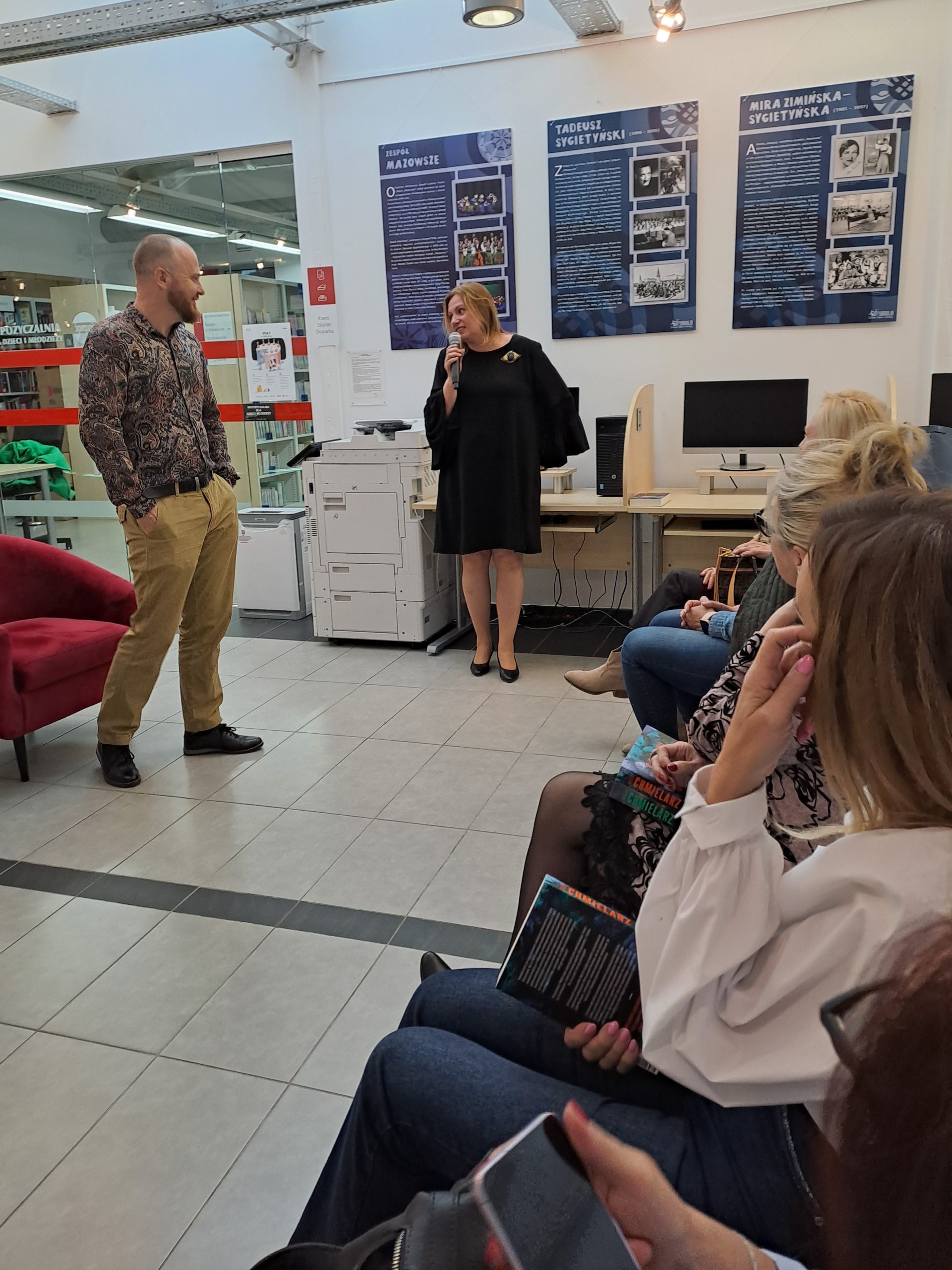 Dyrektor biblioteki dziękuje Wojciechowi Chmielarzowi za spotkanie, autor stoi z rękami w kieszeniach
