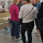 Sesja autografów z Wojciechem Chmielarzem - autor podpisuje książki, otoczony przez uczestników spotkania