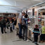 Grupa osób ogląda książki na kiermaszu