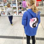 Dzieci oglądają gry planszowe na regale w holu