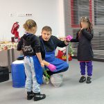 Podczas warsztatów kuchni molekularnej - prowadzący z dwiema uczestniczkami mrozi róże w azocie