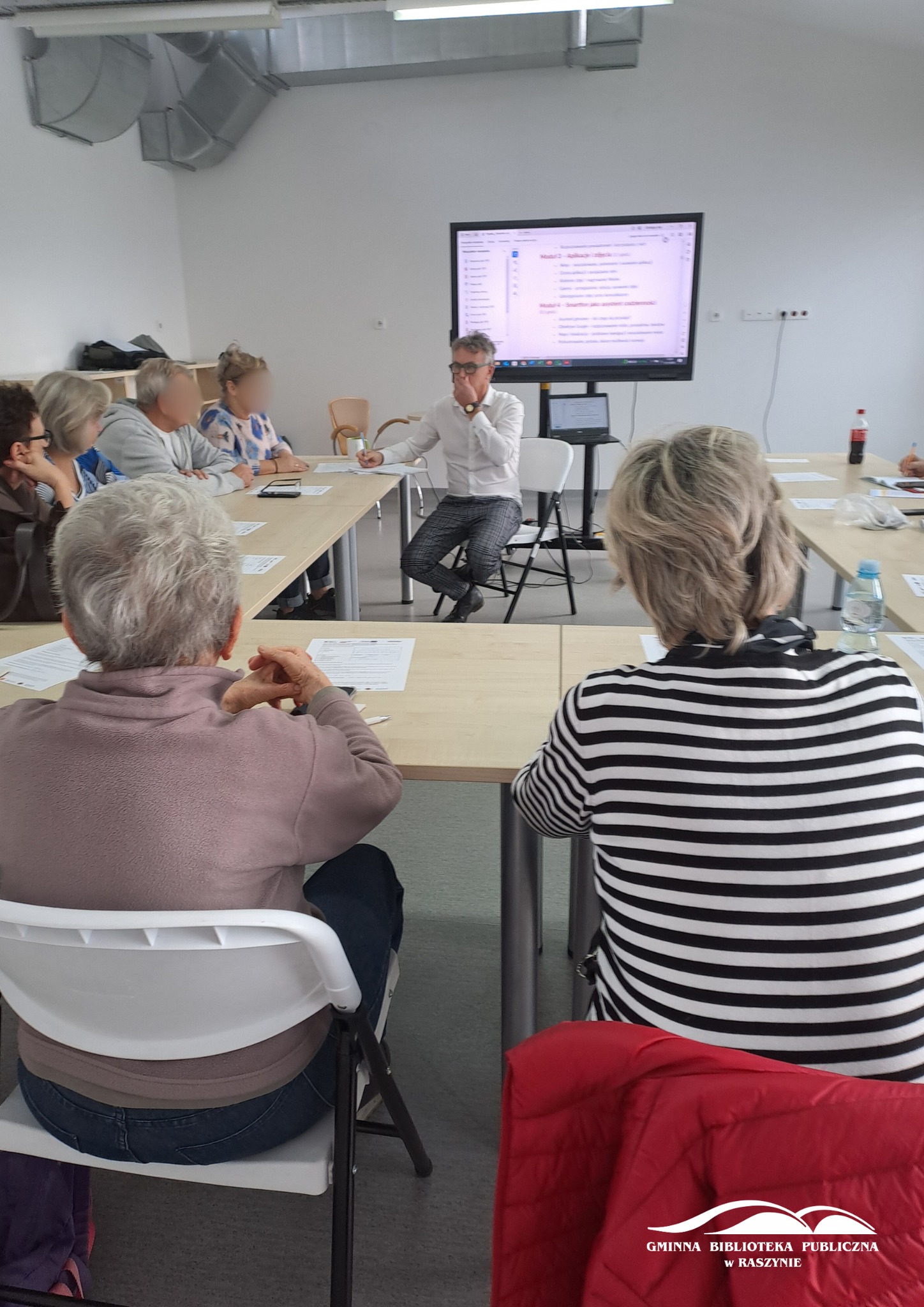 Grupa uczestników zajęć z obsługi smartfona wraz z prowadzącycm