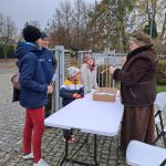 Stoisko z grą - widać prowadzącą i rodzinę uczestniczącą w grze