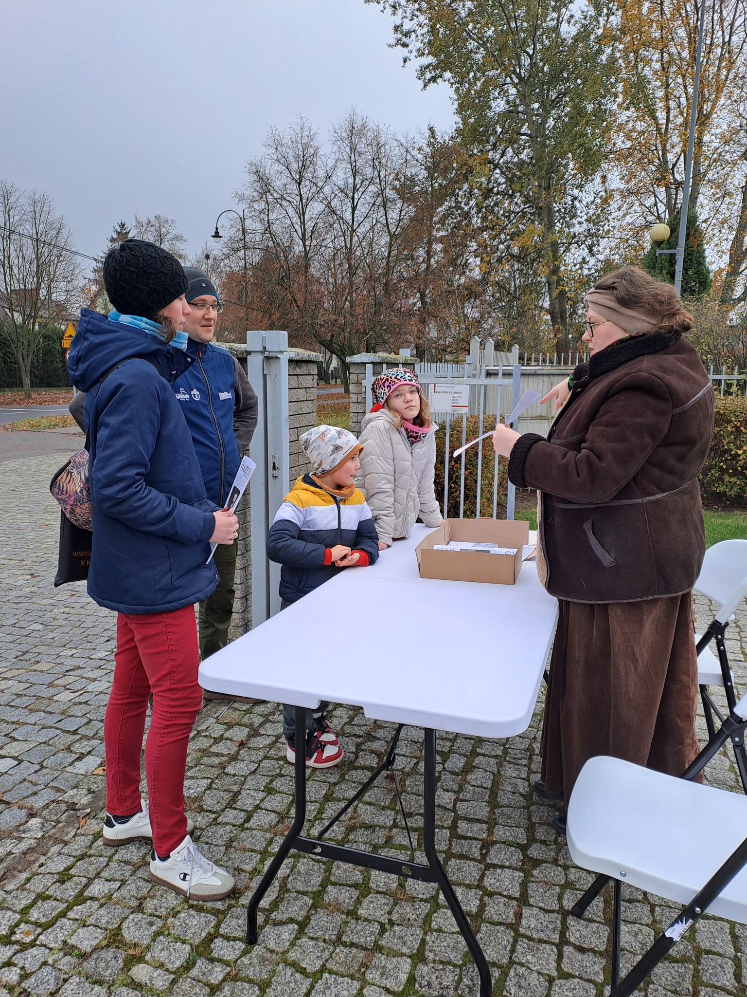 Stoisko z grą - widać prowadzącą i rodzinę uczestniczącą w grze