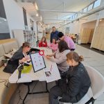 Warsztaty tworzenia kokard patriotycznych - grupa uczestników przy stole