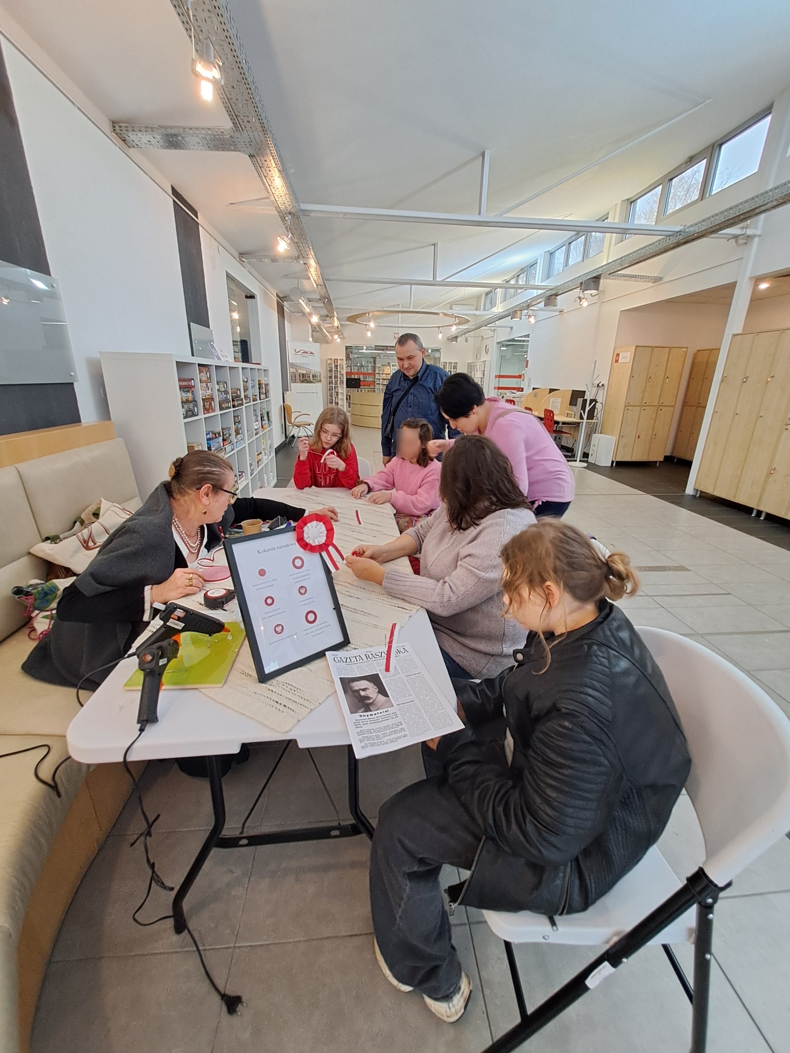 Warsztaty tworzenia kokard patriotycznych - grupa uczestników przy stole