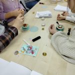 Uczestnicy podczas odciskania pieczęci w kolorowym wosku