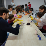 Uczestnicy siedzą wokół stołu, wlewają ocet do szklanek