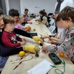 Uczestnicy podłączają woltomierze do cytryny