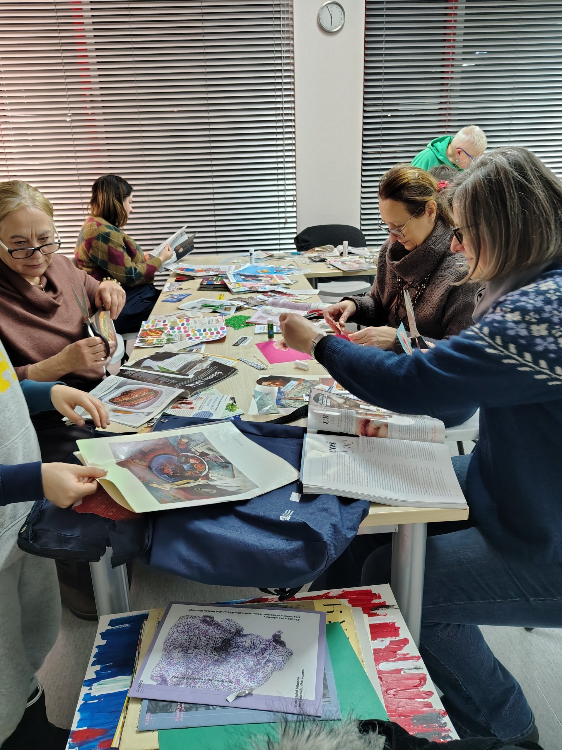 Grupa uczestników warsztatów kolażowych podczas pracy nad kolażami