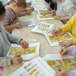 Dzieci pracują nad zadaniami na podstawie książki