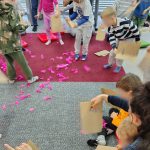 Uczestnicy warsztatów na dywanie z piórkami