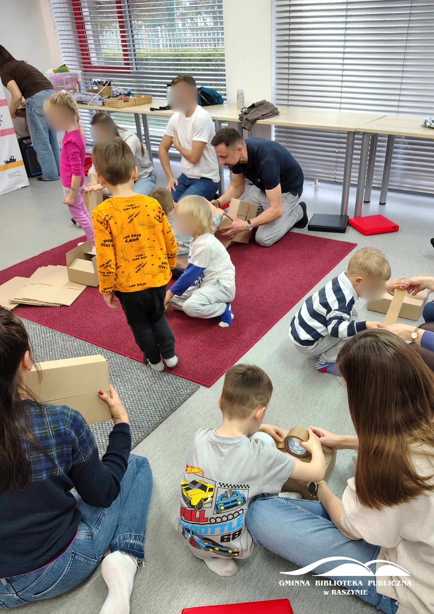 Uczestnicy warsztatów podczas zabawy z tekturowymi pudełkami