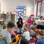 Uczestnicy warsztatów podczas wykonywania prac plastycznych, widoczna też prowadząca