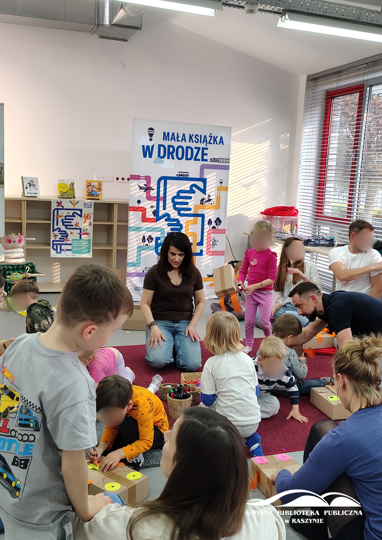 Uczestnicy warsztatów podczas wykonywania prac plastycznych, widoczna też prowadząca