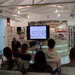 Ekran z fotografią likwidatorów podczas pracy, widoczna część publiczności