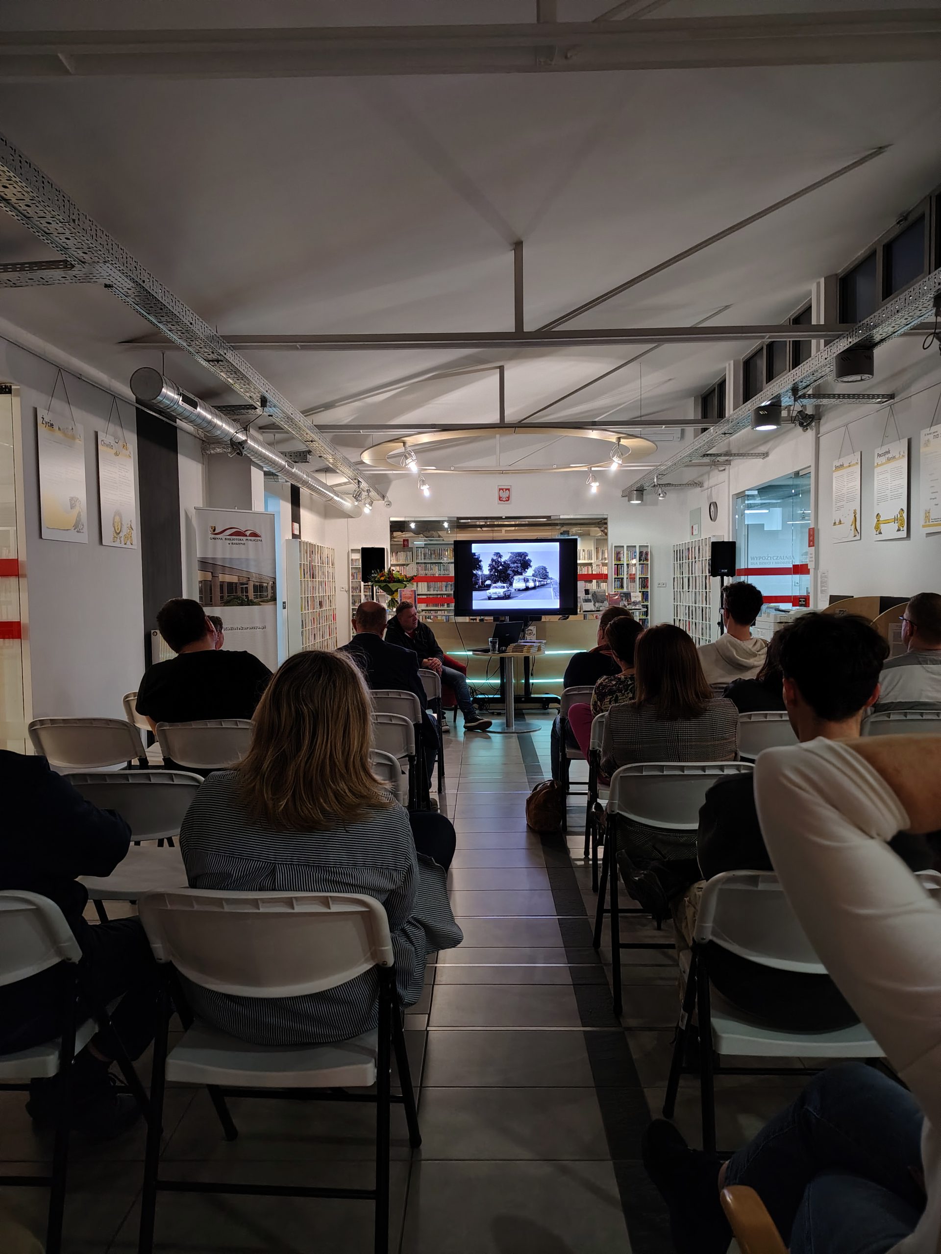 Widok na publiczność (od tyłu). Pośrodku ekran z fotografią likwidatorów podczas pracy