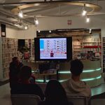 Borys Tynka siedzi na fotelu, widoczny ekran z fotografią bloków w Prypeci