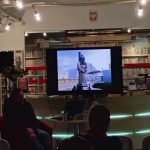 Ekran z fotografią pomnika-arki w Czarnobylu, widoczna część publiczności