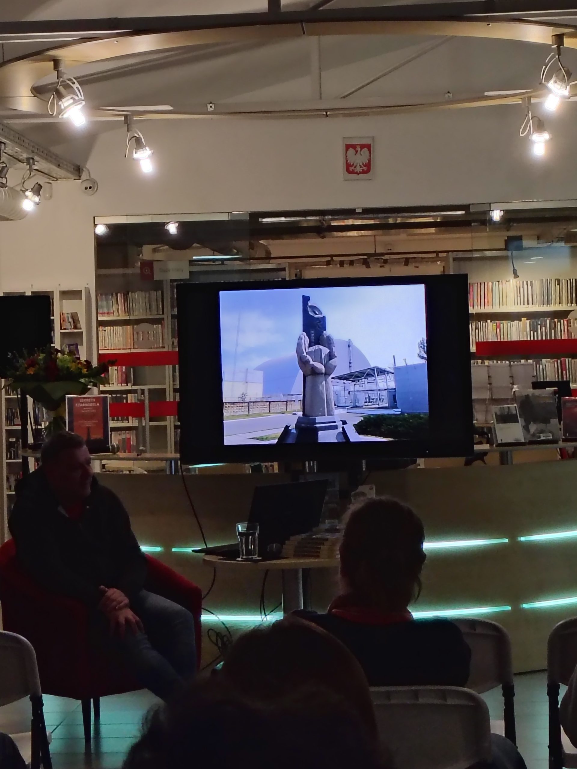 Ekran z fotografią pomnika-arki w Czarnobylu, widoczna część publiczności