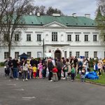 Grupa uczestników biegu Złotych Pszczół na tle pałacu w Falentach