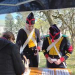 Rekonstruktorzy przy stoisku biblioteki czekają na przypinki