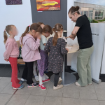 Dzieci stoją w kolejce po pamiątkową przypinkę
