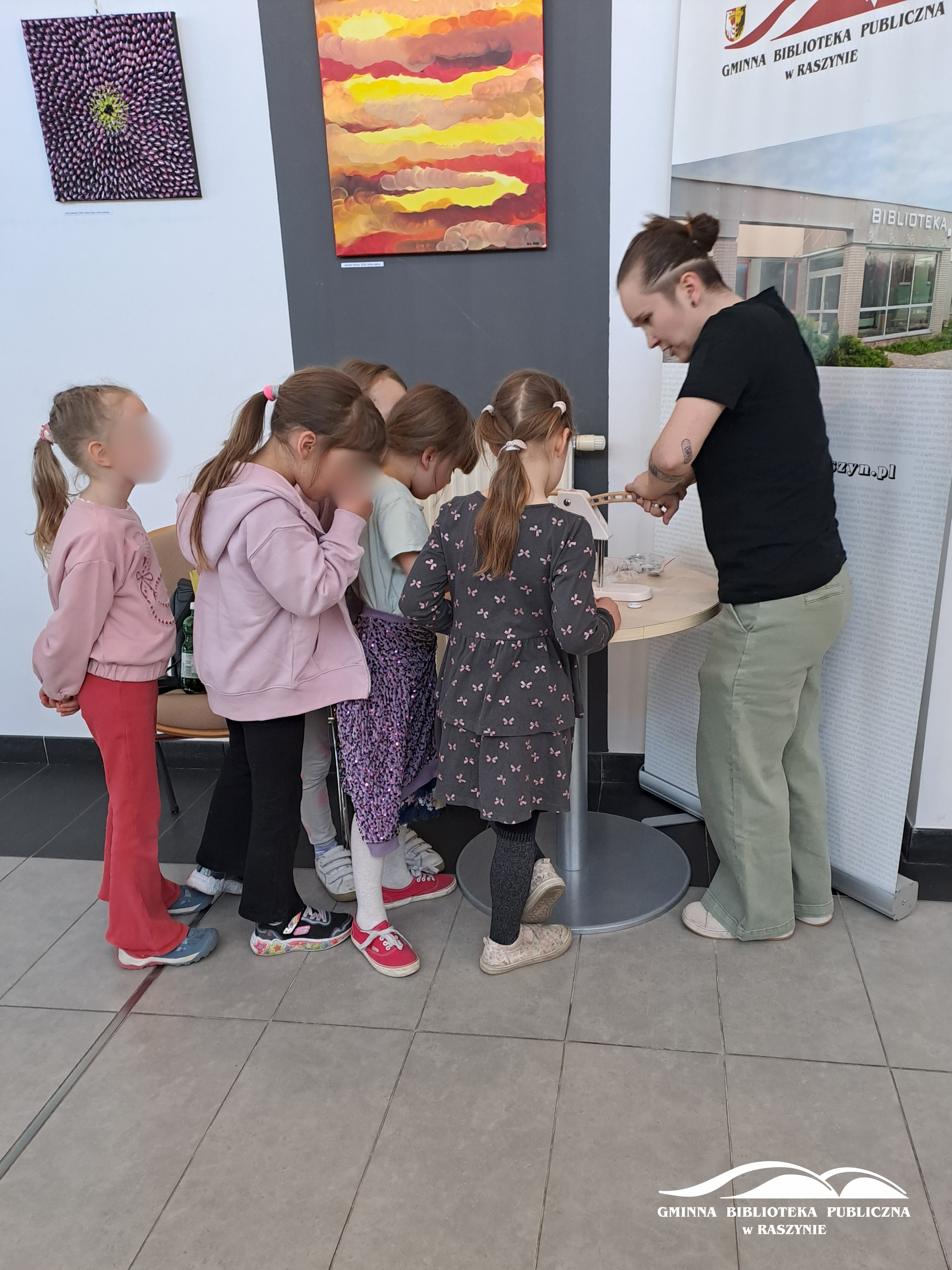 Dzieci stoją w kolejce po pamiątkową przypinkę