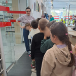 Dzieci zwiedzają bibliotekę - widoczna bibliotekarka