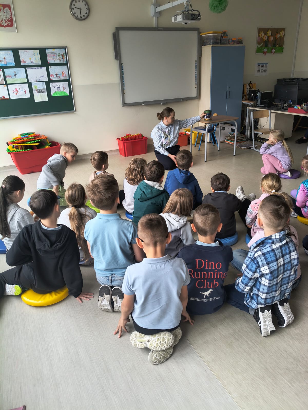 Dzieci i bibliotekarka podczas lekcji bibliotecznej w świetlicy szkolnej