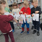 Dzieci podczas wieszania papierowego "prania" na sznurku