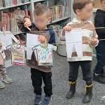 Dzieci wieszają papierowe "pranie" na sznurku