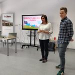 Dyrektor biblioteki wita prowadzącego w bibliotece, widoczny ekran z tytułem warsztatów