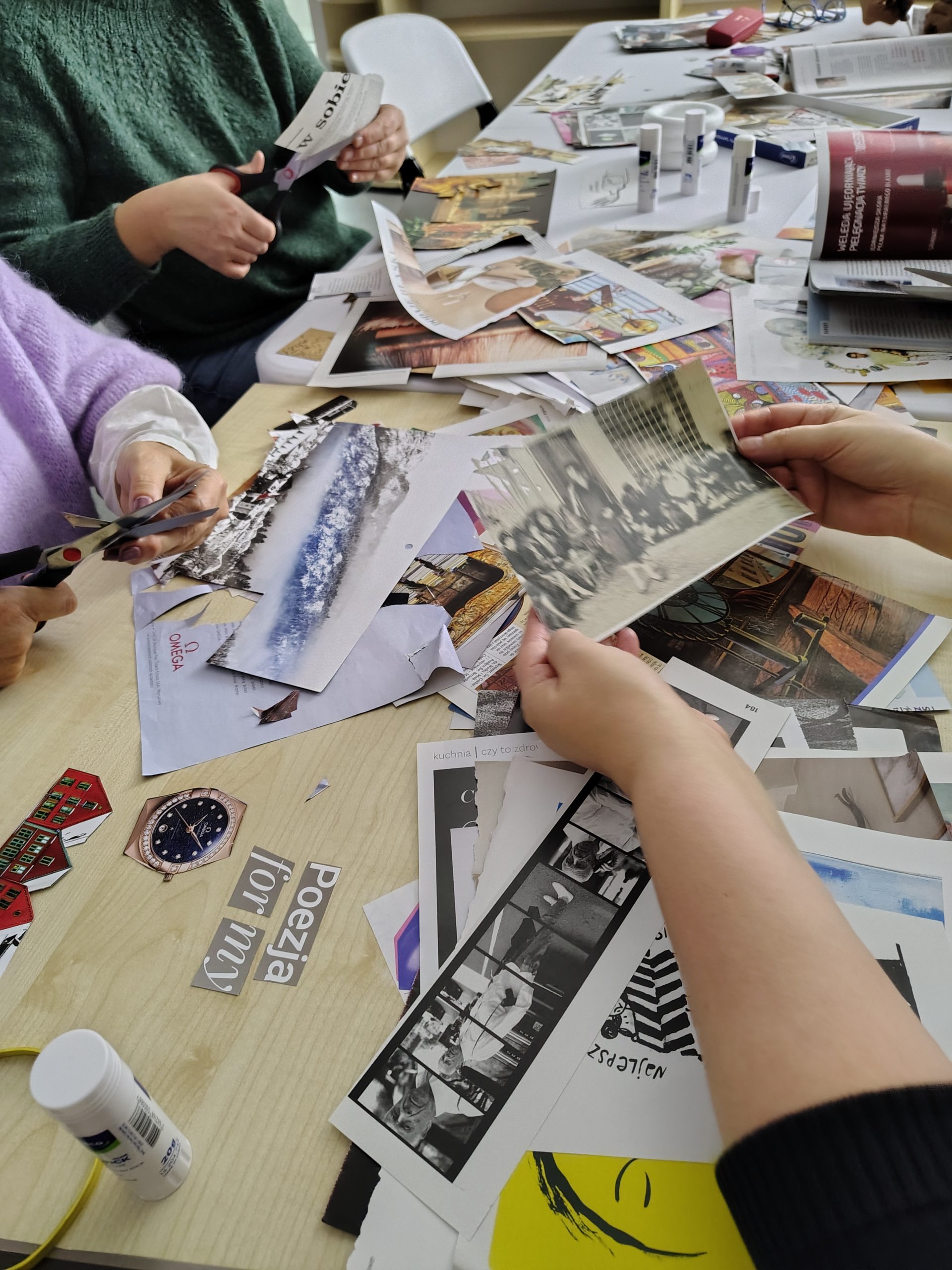 Stół z wycinankami z papieru, cytatami, ilustracjami do powstających kolaży