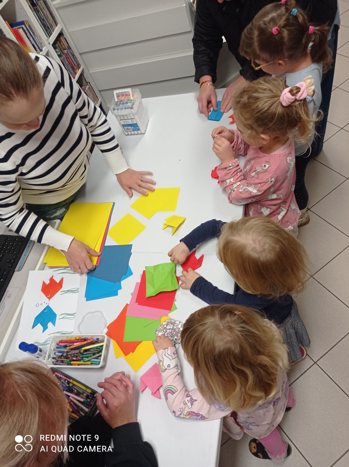 Grupa dzieci pracuje nad wyklejankami papierowymi podczas spotkania w filii w Jaworowej.