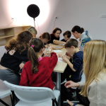 Grupa uczestników warsztatów siedzi wokół stołu