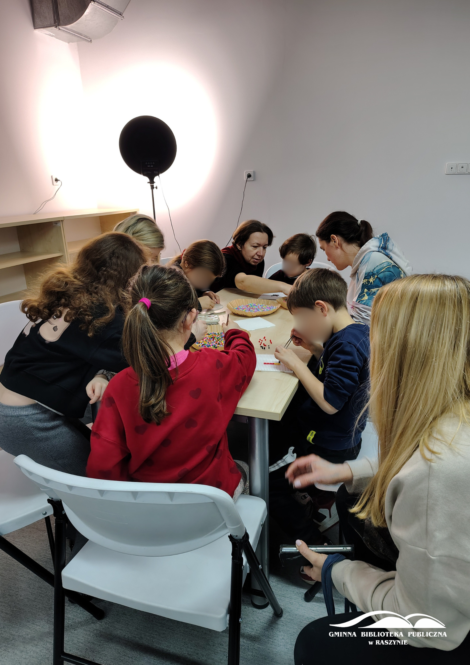 Grupa uczestników warsztatów siedzi wokół stołu