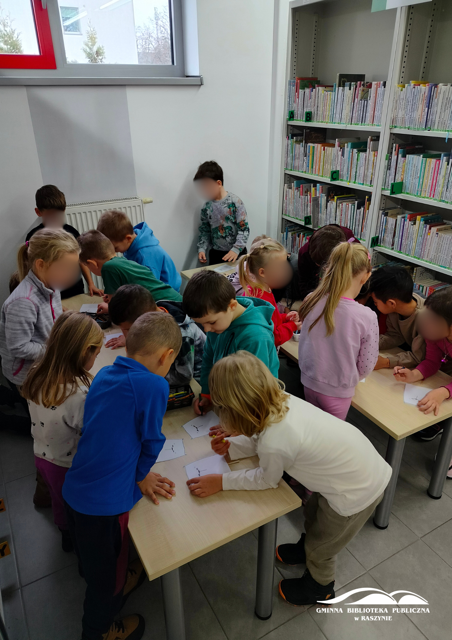 Dzieci kolorują misiowe pacynki przy stołach