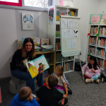 Bibliotekarka pokazuje dzieciom ilustracje z książki o misiu Tulisiu