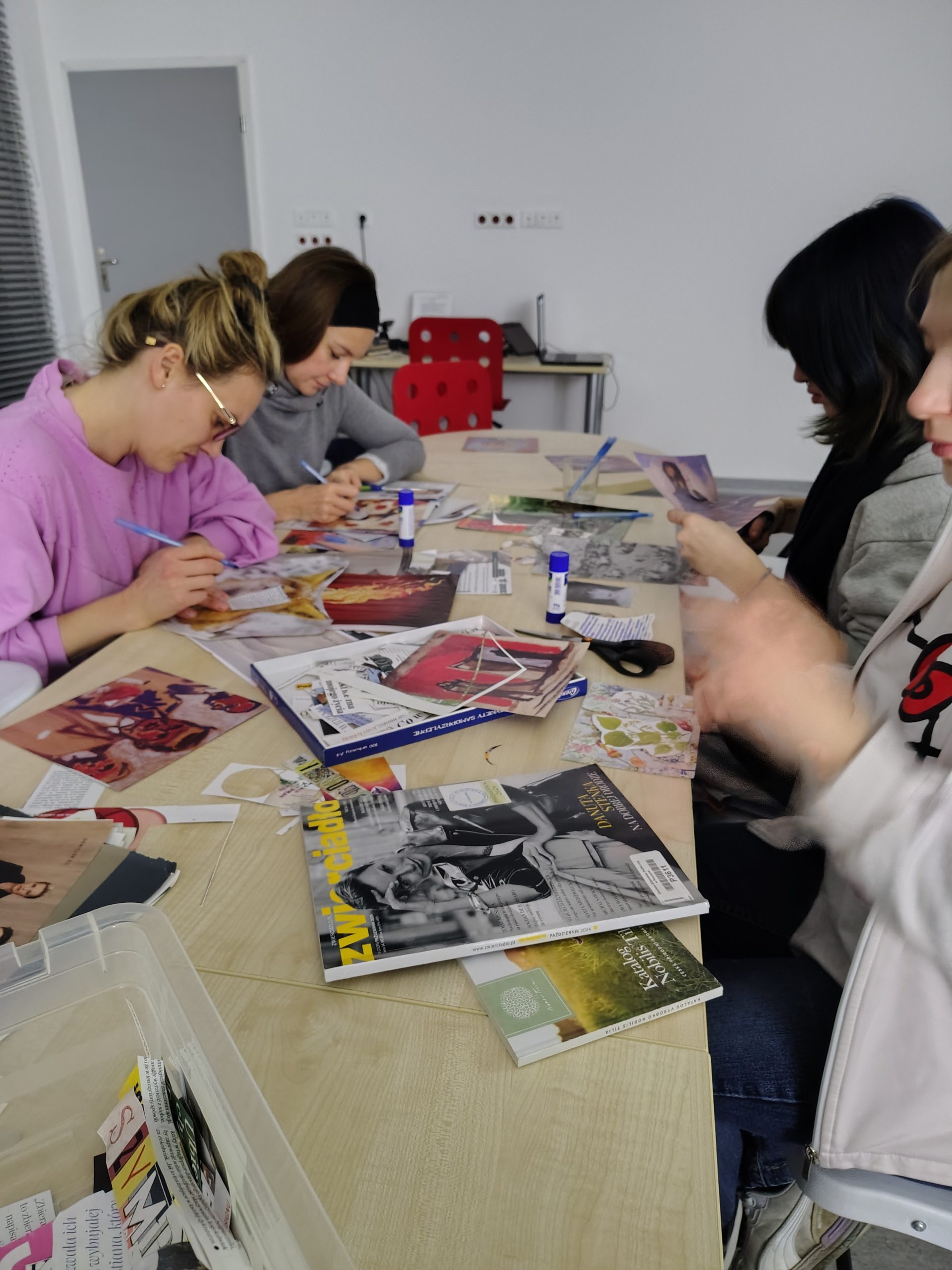 Uczestniczki warsztatów kolażowych podczas pracy - zbliżenie na stół z materiałami