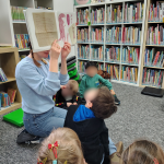 Bibliotekarka pokazuje ilustracje z książki "Dzień w którym kredki miały dość"