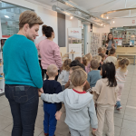 Grupa dzieci stoi w holu oczekując na rozpoczęcie lekcji bibliotecznej