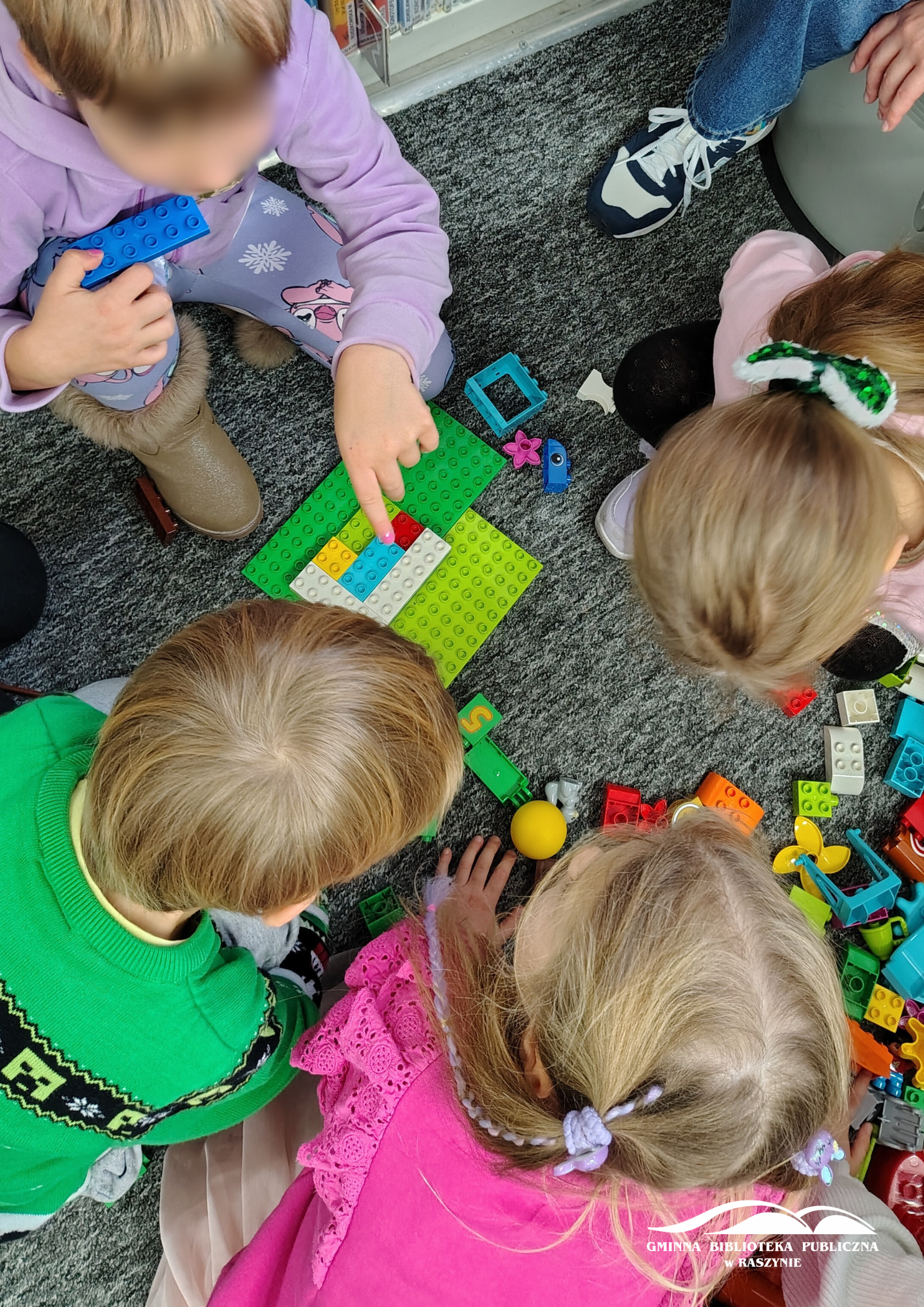 Grupka dzieci pracuje nad wspólnym pojazdem dla Mikołaja