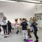 Zabawa w kolory - uczniowie stoją w grupkach przy kolorowych kartkach na podłodze