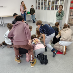 Zabawa w kolory - uczniowie kucają wokół kartki na podłodze